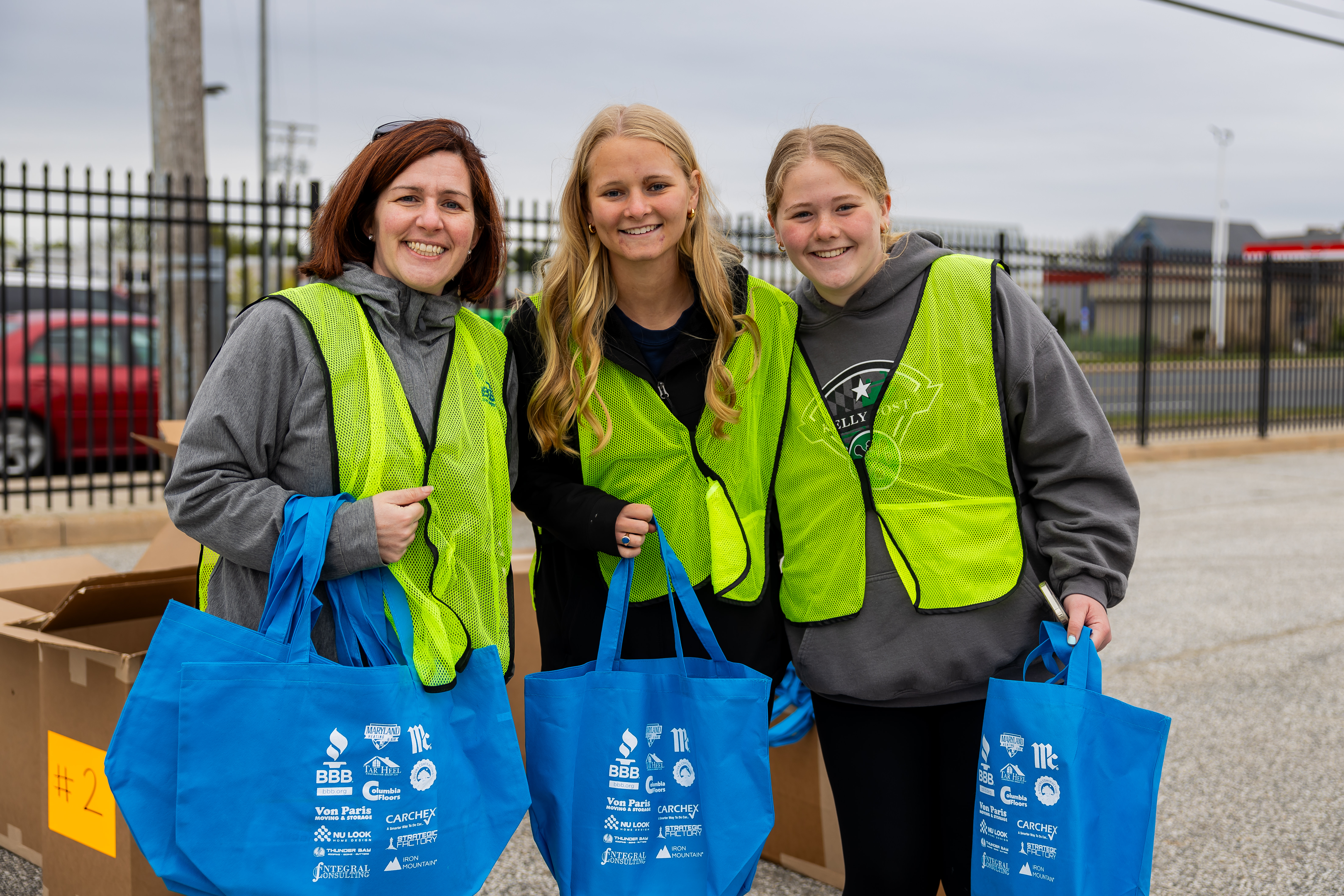 Sponsor-logo tote bags being handed out and carried at BBB Shred Day.