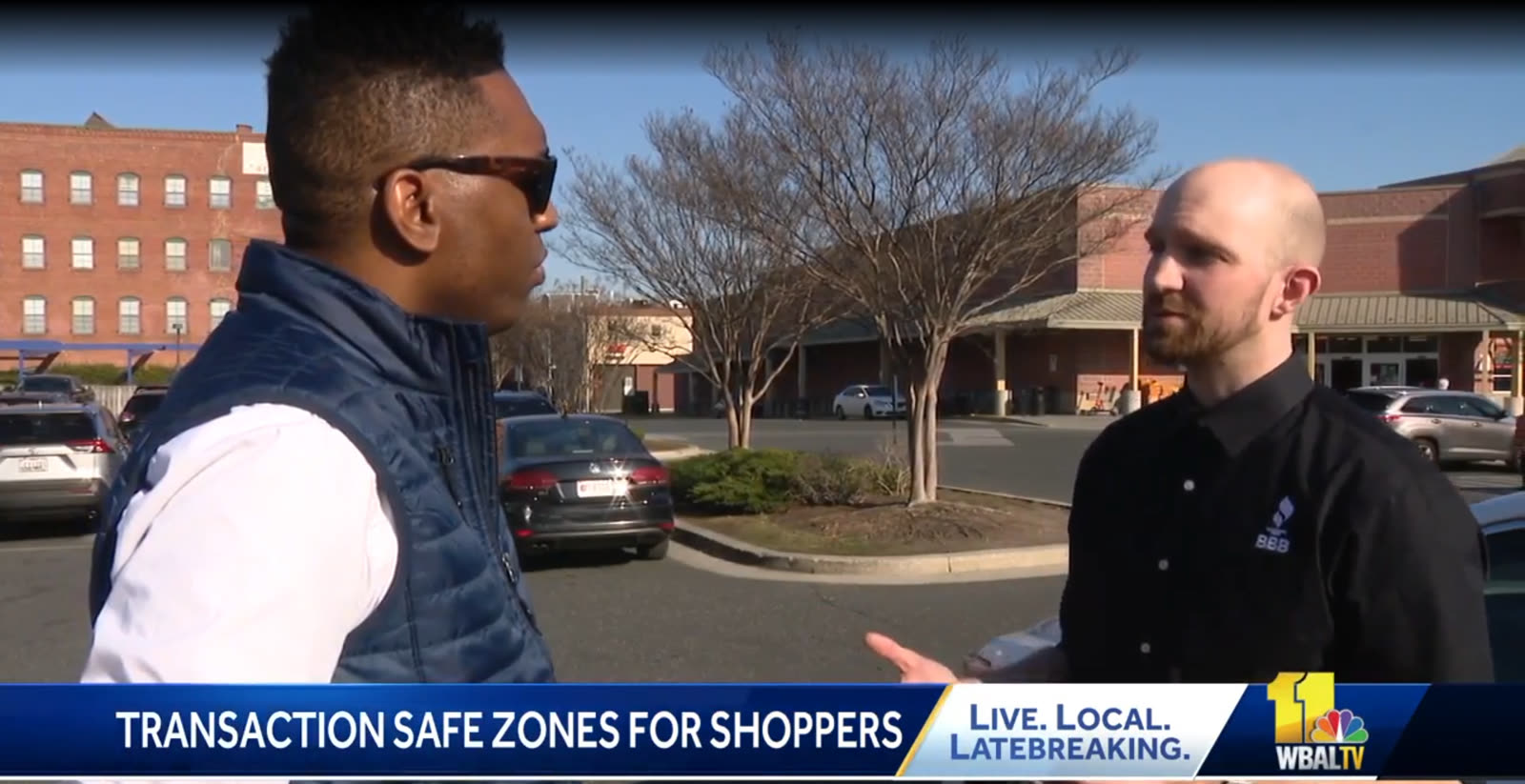 A WBAL-TV reporter interviewing a shopper in a parking lot, with the lower third reading transaction safe zones for shoppers.